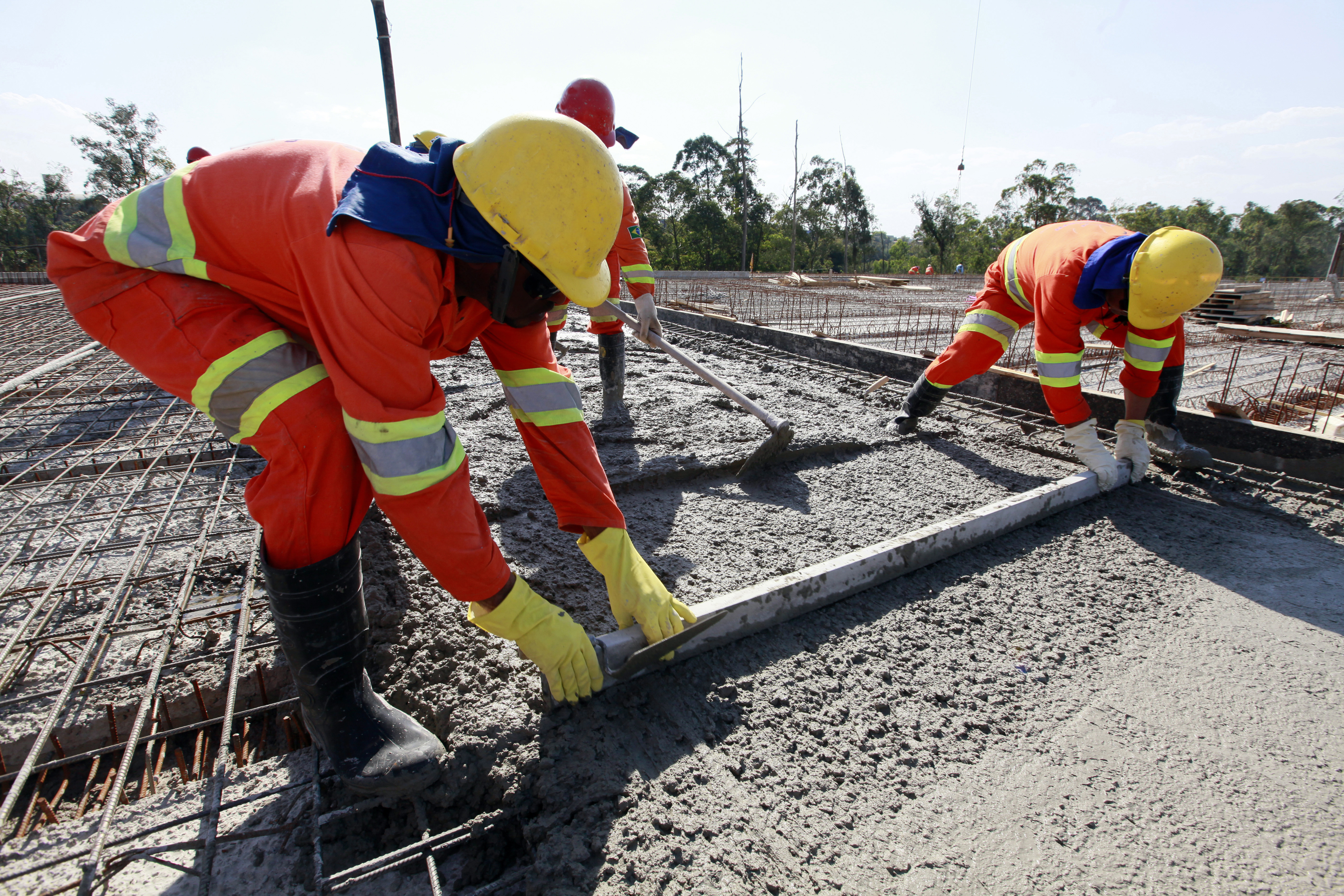 road construction workers pouring cement in road construction on brazil